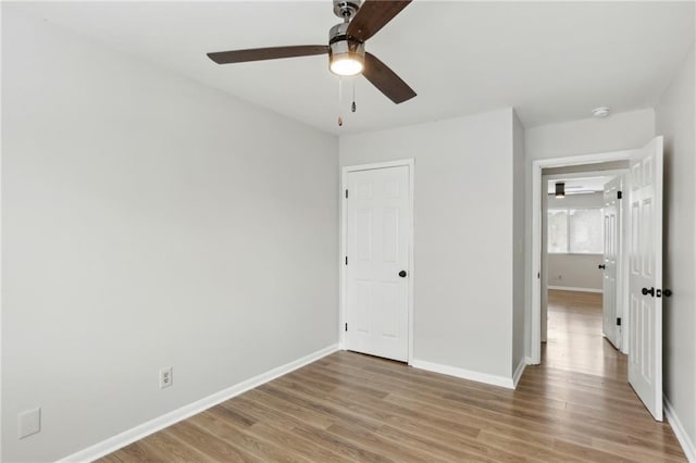 unfurnished bedroom featuring ceiling fan, light hardwood / wood-style floors, and a closet