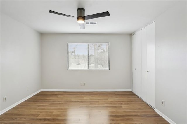 empty room featuring wood-type flooring and ceiling fan