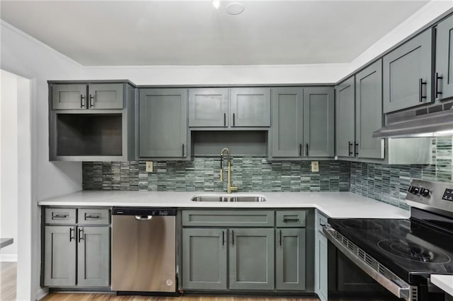 kitchen featuring tasteful backsplash, stainless steel appliances, sink, and gray cabinetry