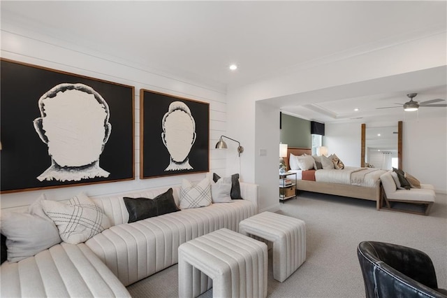 carpeted bedroom featuring ceiling fan and a raised ceiling