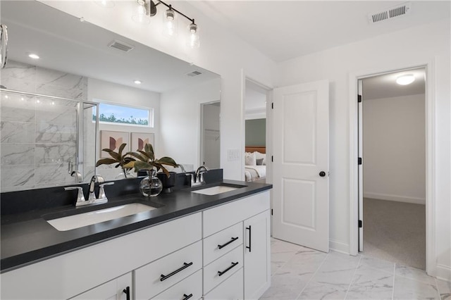 bathroom featuring a shower with shower door and vanity