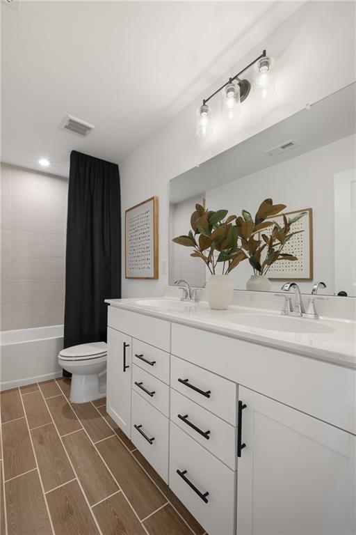 full bathroom with toilet, shower / bath combo, and vanity