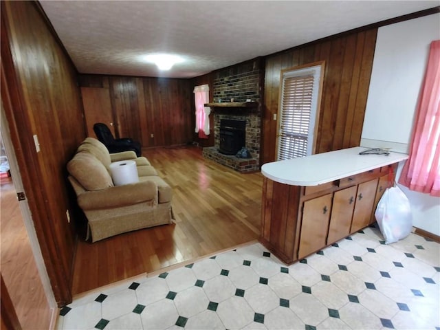 living room with a brick fireplace and wood walls