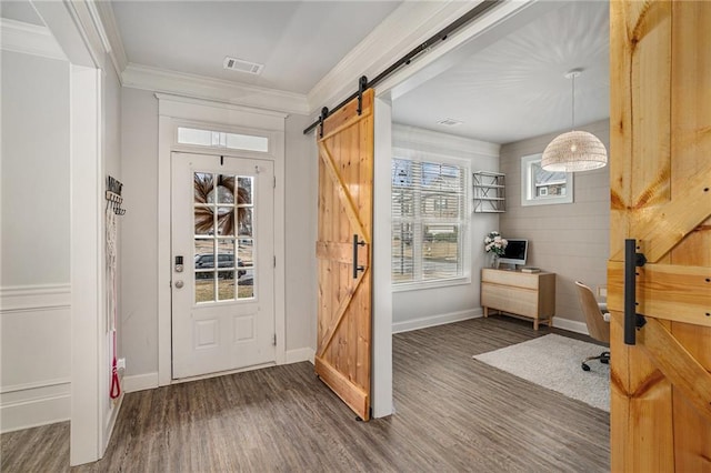 doorway to outside with a barn door, crown molding, and dark wood-type flooring