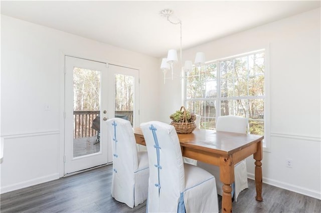 dining area with french doors, an inviting chandelier, plenty of natural light, and dark wood-type flooring