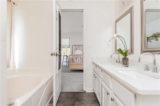 bathroom featuring hardwood / wood-style floors, vanity, and a bathing tub