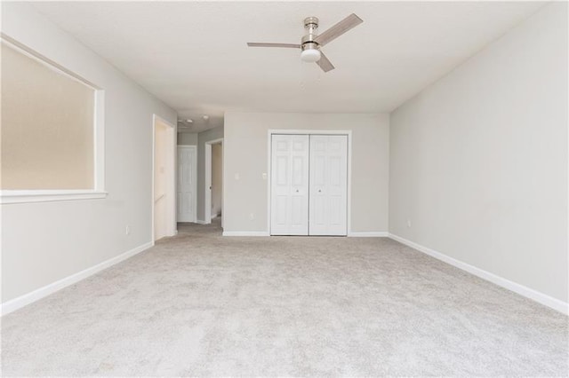 unfurnished bedroom with ceiling fan, a closet, and light carpet