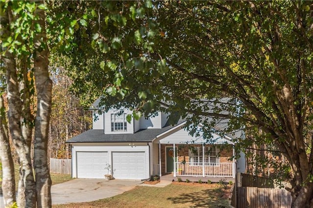 view of front of property featuring a porch, a garage, and a front yard