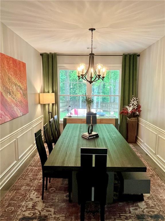 2278 Traywick Chase, Alpharetta, GA 30004 - dining area featuring a healthy amount of sunlight, a decorative wall, a chandelier, and wainscoting