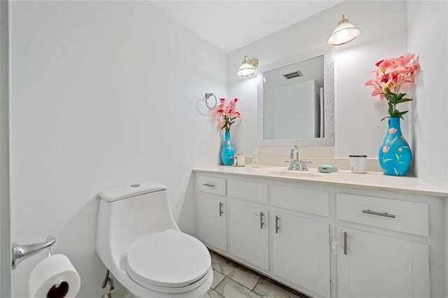 half bath featuring visible vents, marble finish floor, vanity, and toilet