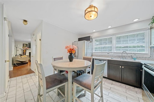 kitchen featuring recessed lighting, backsplash, appliances with stainless steel finishes, a sink, and dark brown cabinetry