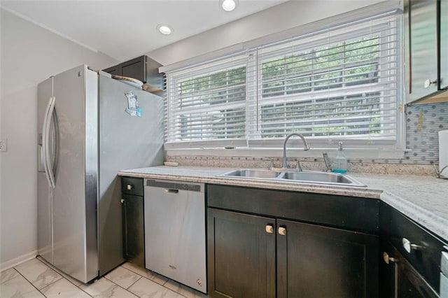 kitchen with stainless steel appliances, a sink, light countertops, and a healthy amount of sunlight