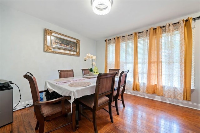 dining space with baseboards and wood finished floors