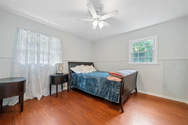 bedroom featuring ceiling fan, wood finished floors, and baseboards