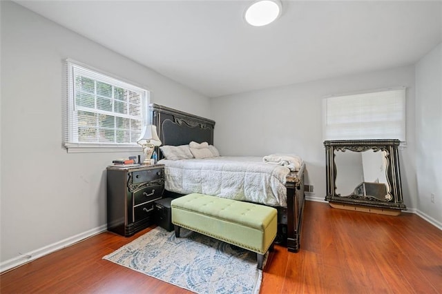 bedroom with dark wood-style floors and baseboards