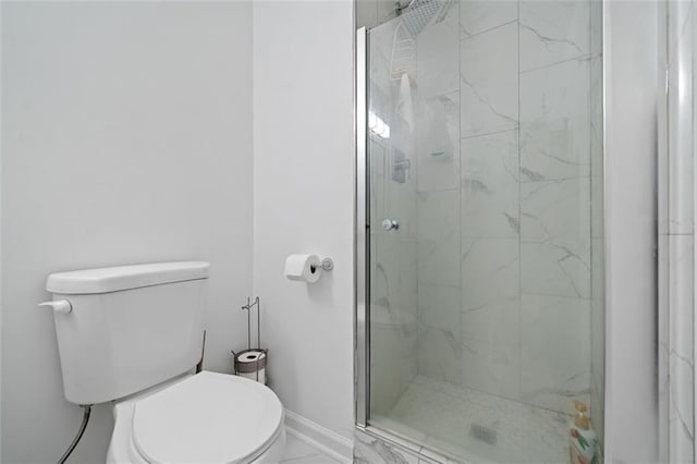 bathroom with marble finish floor, a marble finish shower, toilet, and baseboards