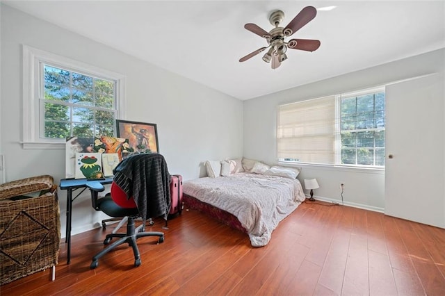 bedroom with ceiling fan, baseboards, and wood finished floors