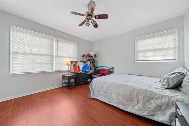 bedroom with wood finished floors, a ceiling fan, and baseboards