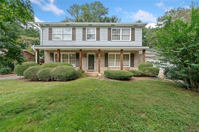 view of front of home with covered porch, brick siding, a front lawn, and an attached garage