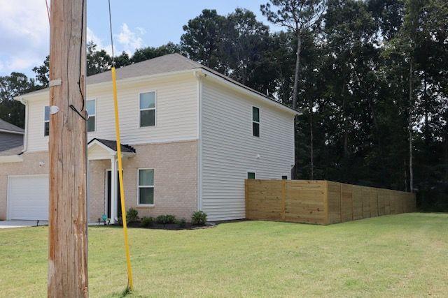 view of side of property with a yard and a garage