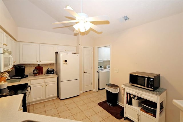 kitchen with visible vents, independent washer and dryer, white appliances, and white cabinetry