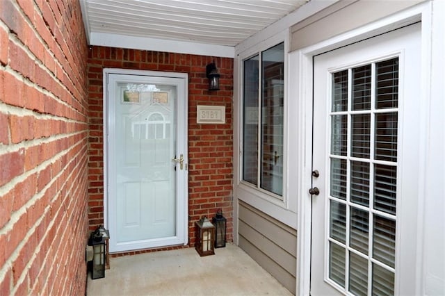 doorway to property with brick siding