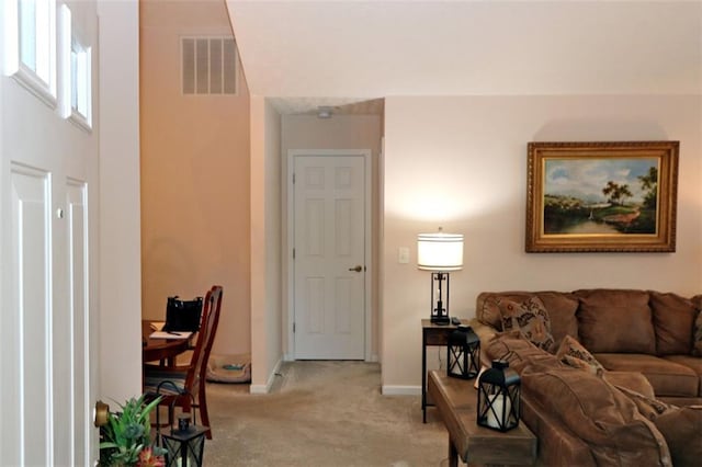 living area with visible vents, light colored carpet, and baseboards