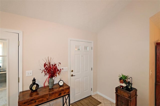 foyer featuring vaulted ceiling and light tile patterned flooring