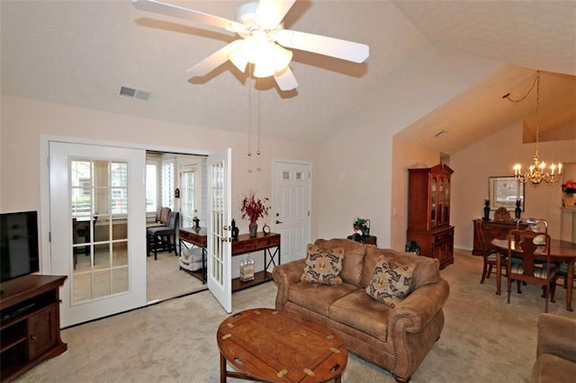 living area featuring visible vents, lofted ceiling, light carpet, ceiling fan with notable chandelier, and french doors