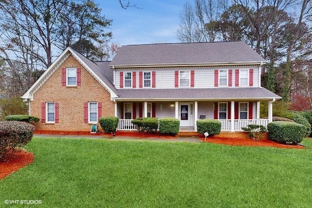 colonial home with covered porch and a front yard