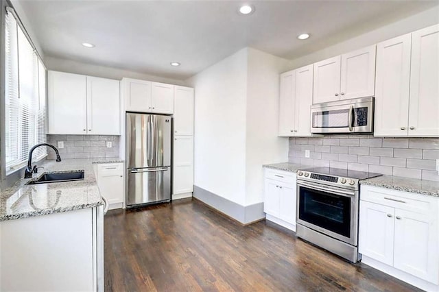1497 Rogers Ave, Atlanta, GA 30310 - kitchen featuring appliances with stainless steel finishes, light stone countertops, recessed lighting, dark wood finished floors, and white cabinets