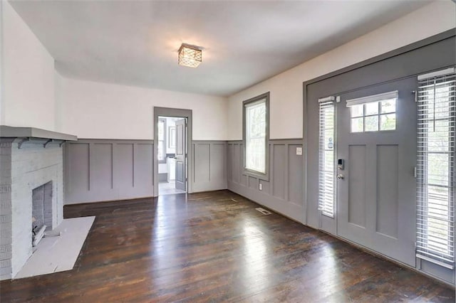 1497 Rogers Ave, Atlanta, GA 30310 - unfurnished living room featuring wainscoting, wood finished floors, a decorative wall, and a brick fireplace