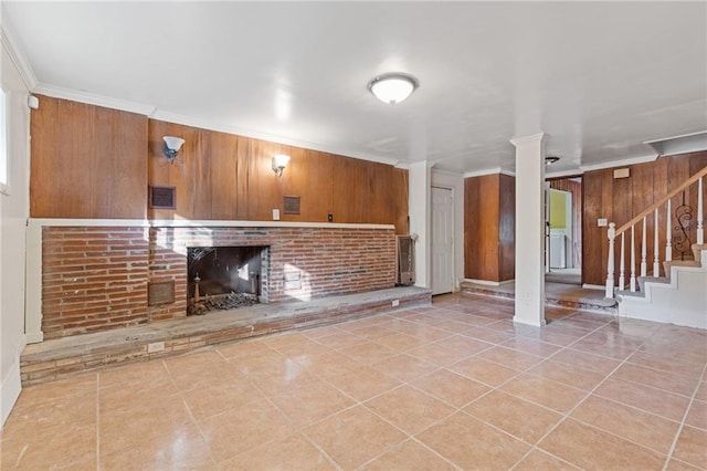 2081 Dodson Dr SW, Atlanta, GA 30311 - unfurnished living room featuring a brick fireplace, tile patterned flooring, stairway, ornamental molding, and wood walls