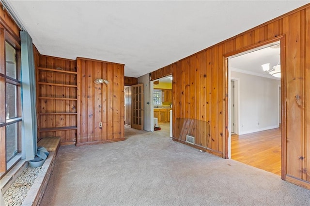 2081 Dodson Dr SW, Atlanta, GA 30311 - unfurnished living room featuring wooden walls, ornamental molding, carpet floors, baseboards, and built in features