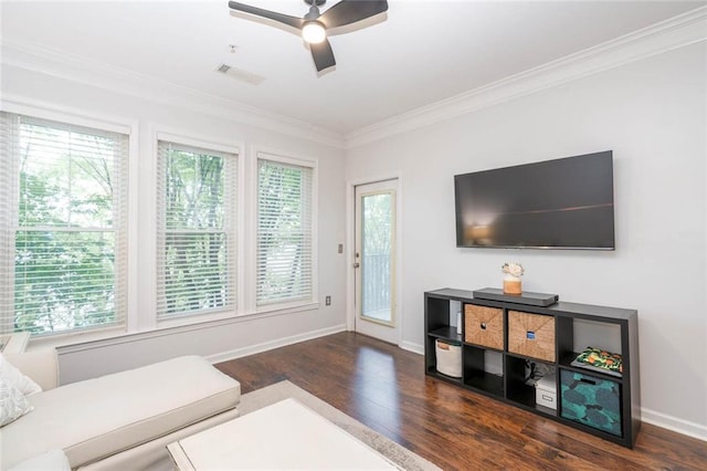 living area featuring wood finished floors, crown molding, healthy amount of natural light, baseboards, and ceiling fan