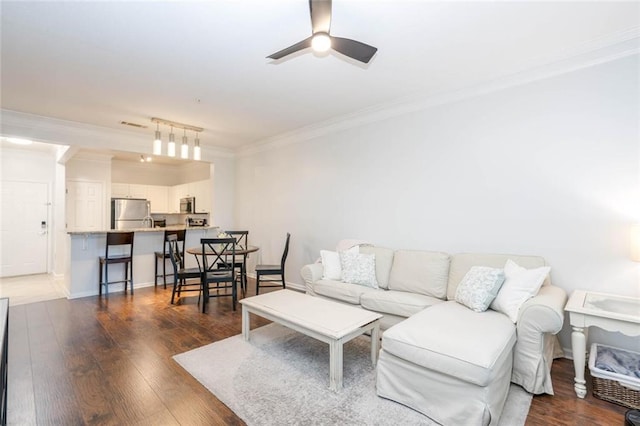 living area with a ceiling fan, crown molding, and wood finished floors