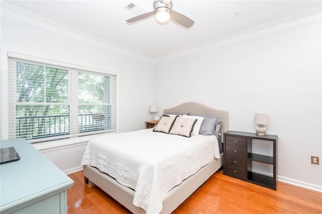 bedroom with light wood-style floors, crown molding, baseboards, and a ceiling fan