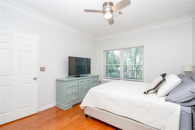 bedroom featuring ornamental molding, light wood-style floors, a ceiling fan, and baseboards
