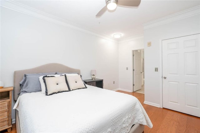 bedroom featuring crown molding, light wood finished floors, a ceiling fan, and baseboards