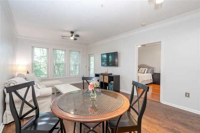 dining space with ceiling fan, dark wood finished floors, crown molding, and baseboards