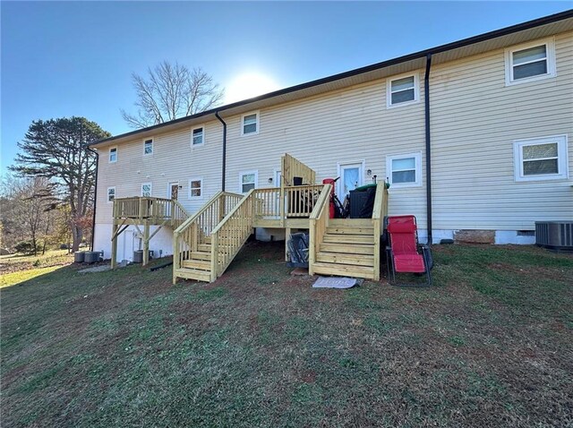 rear view of house with a wooden deck, cooling unit, and a yard