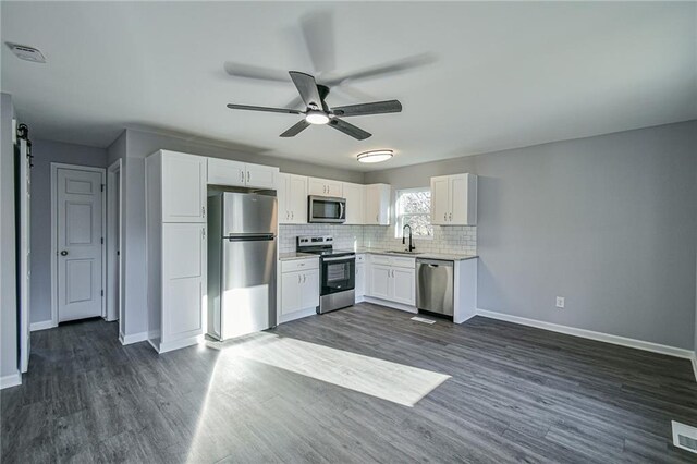 kitchen featuring tasteful backsplash, ceiling fan, sink, white cabinetry, and stainless steel appliances