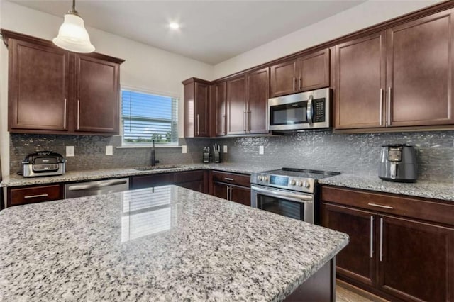 1130 Lyndhurst Ln, Bethlehem, GA 30620 - kitchen featuring appliances with stainless steel finishes, light stone counters, pendant lighting, and dark brown cabinetry