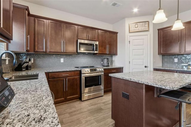 1130 Lyndhurst Ln, Bethlehem, GA 30620 - kitchen with stainless steel appliances, tasteful backsplash, light stone countertops, a kitchen breakfast bar, and light wood-style floors