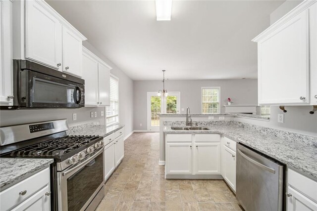 kitchen with kitchen peninsula, white cabinetry, sink, and appliances with stainless steel finishes