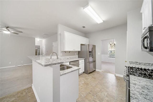 kitchen with kitchen peninsula, appliances with stainless steel finishes, white cabinetry, and sink