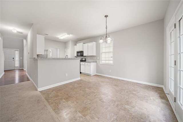 kitchen featuring an inviting chandelier, kitchen peninsula, fridge, decorative light fixtures, and white cabinets