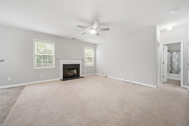 unfurnished living room featuring light colored carpet and ceiling fan