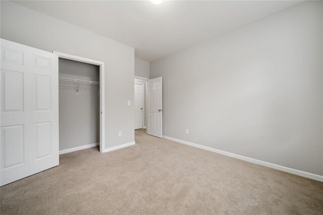 unfurnished bedroom featuring a closet and light colored carpet