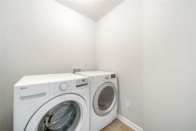 washroom featuring washer and dryer and light tile patterned floors